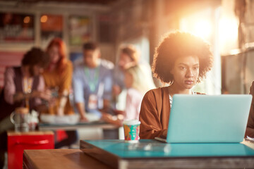 Young beautiful woman in the office is focused on a work on the laptop