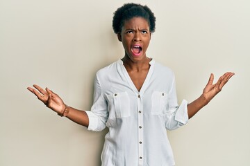 Young african american girl wearing casual clothes crazy and mad shouting and yelling with aggressive expression and arms raised. frustration concept.