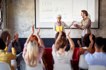 Group of young creative people is expressing their satisfaction with a presentation in the...