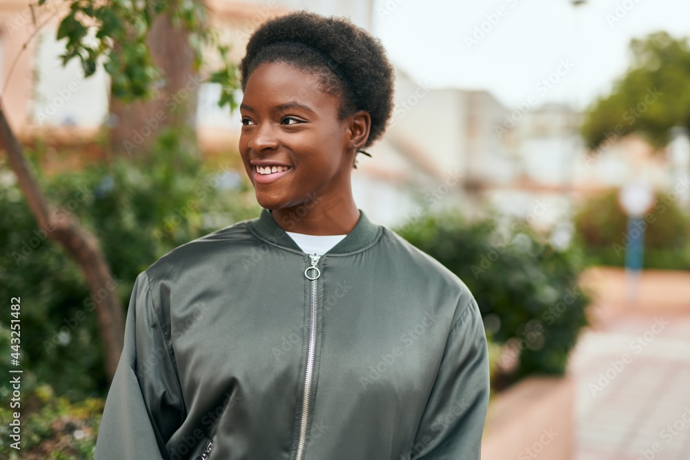 Sticker Young african american girl smiling happy standing at the city.