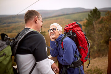 An elderly couple in love enjoying the view from the top of a watchtower