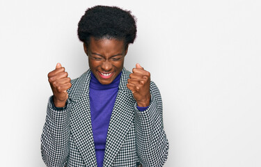 Young african american girl wearing casual clothes excited for success with arms raised and eyes...