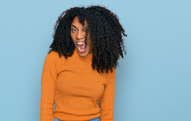 Young african american girl wearing casual clothes winking looking at the camera with sexy...