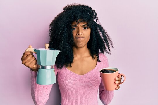African american woman with afro hair drinking italian coffee skeptic and nervous, frowning upset because of problem. negative person. - Powered by Adobe