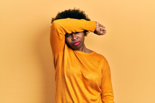 Young african american woman wearing casual clothes covering eyes with arm, looking serious and sad. sightless, hiding and rejection concept