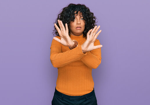 Young hispanic woman wearing casual clothes rejection expression crossing arms doing negative sign, angry face