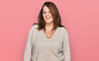 Young plus size woman wearing casual clothes winking looking at the camera with sexy expression, cheerful and happy face.