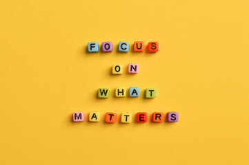 Alphabet letters with text FOCUS ON WHAT MATTERS isolated on yellow background