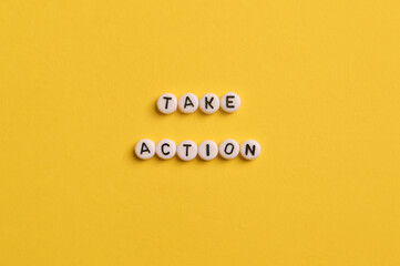 Alphabet letters with text TAKE ACTION isolated on yellow background