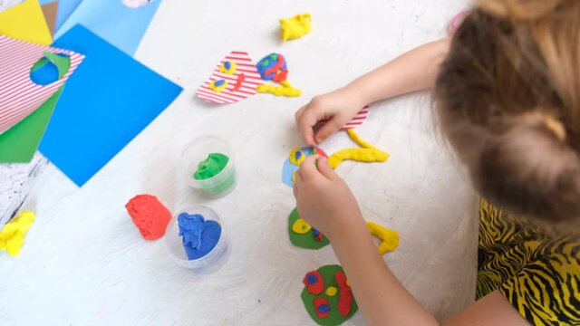 Child modeling fun craft . Modeling clay, plasticine and paper crafts idea for kids. Activity in kindergarten and at home. 