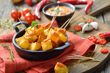 Patatas Bravas mit scharfer Chili-Sauce, ein Klassiker unter den spanischen Tapas-Gerichten – Spanish fried potato cubes with spicy chili sauce, traditional appetizers