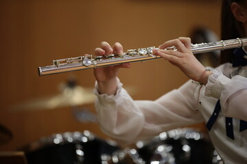 A girl playing the flute. Fingers on the keys. Close-up image