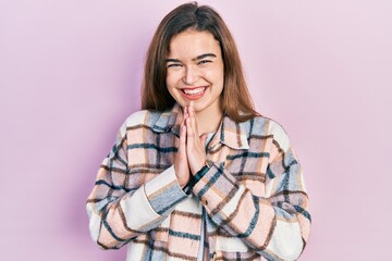 Young caucasian girl wearing casual clothes praying with hands together asking for forgiveness smiling confident.