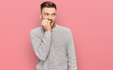 Young redhead man wearing casual winter sweater looking stressed and nervous with hands on mouth biting nails. anxiety problem.