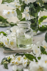 Jasmine essential oil and fresh jasmine blossom. Alternative medicine and natural body care cosmetics. Fresh buds of white flowers.
