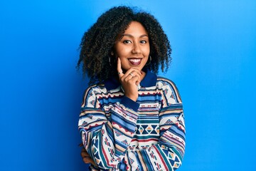 Beautiful african american woman with afro hair wearing casual clothes smiling looking confident at the camera with crossed arms and hand on chin. thinking positive.