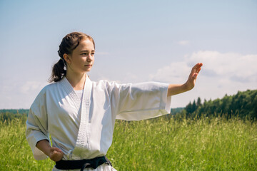 portrait of a teen girl training karate kata outdoors