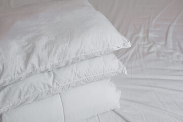 neat stack of bedding pillows and a duvet lie on the bed