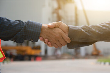 Fototapeta premium Close-up image of a firm handshake between two colleagues on site of building construction