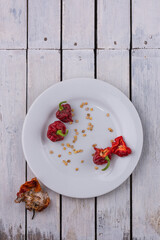 collecting seeds from habanero chili peppers, saved seeds that had been removed from a ripe capsicum chinense placed on a white plate or a tray