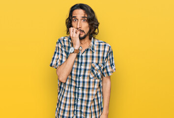 Young hispanic man wearing casual clothes looking stressed and nervous with hands on mouth biting nails. anxiety problem.