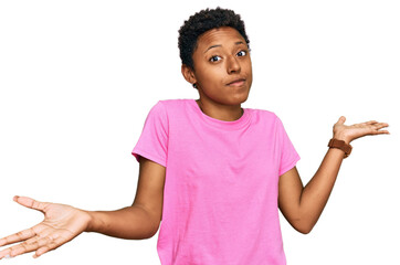 Young african american woman wearing casual clothes clueless and confused expression with arms and...