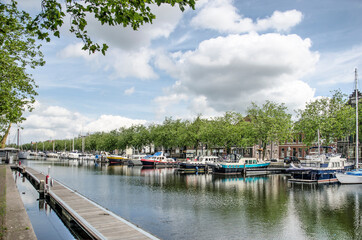 Vlaardingen, The Netherlands, July 4, 2021: view of the town's old harbour lined with yachts, trees...
