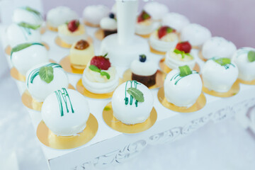 Candy bar. White festive table with deserts, strawberry tartlet and cupcakes. Wedding. Reception Tartlets