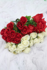red roses and white roses on a white cloth