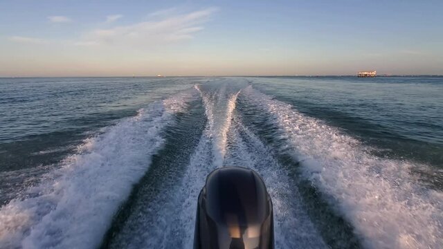 Wake of outboard motor boat passing through Stiltsville in Biscayne National Park, Florida on calm early morning 4K.