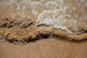 Sea water mixing with  the sand on the beach.