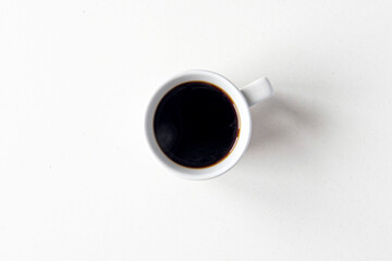 Ceramic mug with hot black coffee, top view as flat lay, space for text