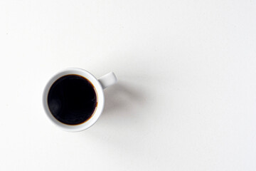 Ceramic mug with hot black coffee, top view as flat lay, space for text