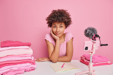 Serious self confident housewife freelancer records tutorial video on smartphone webcam gives...