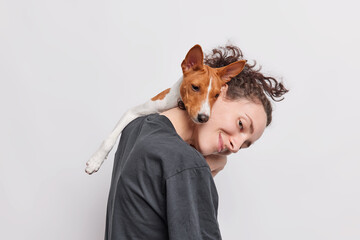 Female pet owner plays with favorite dog which leans on her head being best friends spend time...