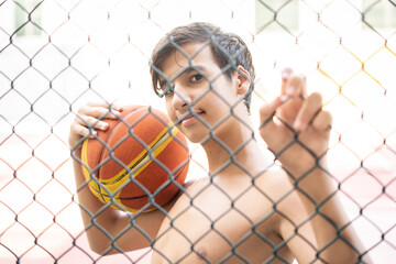 Teenage boy on city playground holding basketball