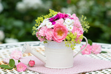 romantischer Blumenstrauß mit pink Rosen in dekorativer Gießkanne