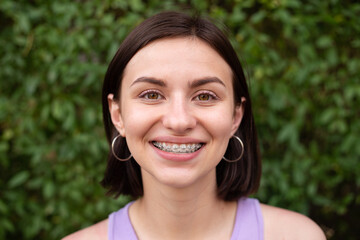Young girl smiling with metal dental braces on teeth