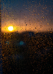  sunset  through the window with drops of rain on it