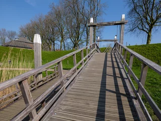 Gordijnen De houten brug over de Historische haven geeft toegang tot de Stadshaven in Woudrichem. © Holland-PhotostockNL