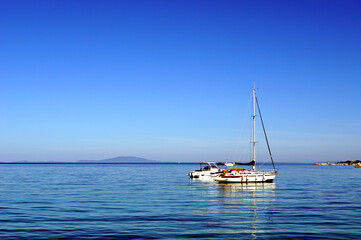 Anchored yacht boats in front of port with background of blue sky and sea