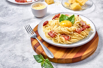 Traditional Italian Pasta Carbonara with bacon, cheese and egg yolk on plate on light background