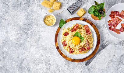 Traditional Italian Pasta Carbonara with bacon, cheese and egg yolk on plate on light background. Top view Flat lay