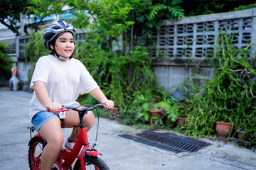 Obraz premium Child learning to ride a bicycle. A little girl learned to ride a balance bike