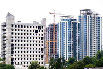 Cranes on a construction site of building of modern residential district High apartment buildings or skyscrapers in new complex.