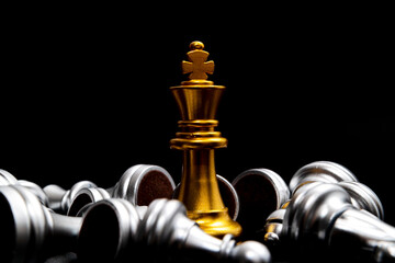 Gold queen chess surrounded by a number of fallen silver chess pieces