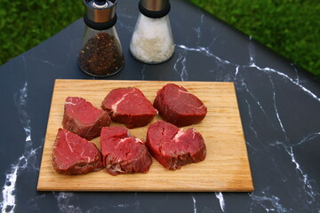 Frisches, saftiges Rinderfilet vom Freilandrind zu Medallions geschnitten auf einem Holzbrett.