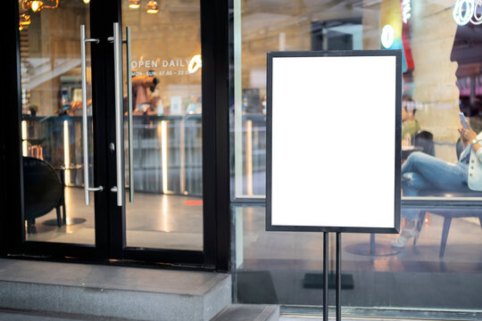 mockup white poster with black frame stand in front of blur restaurant cafe background
