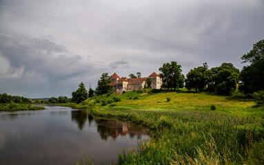 Fototapeta premium Beautiful panorama of Svirzh castle by the river on a summer day, near Lviv.