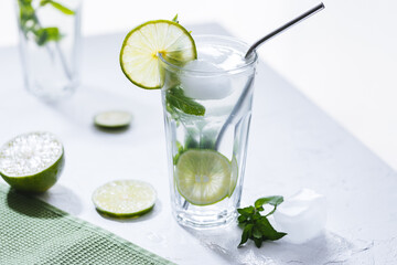 Mojito cocktail with lime and mint with straw on a white background